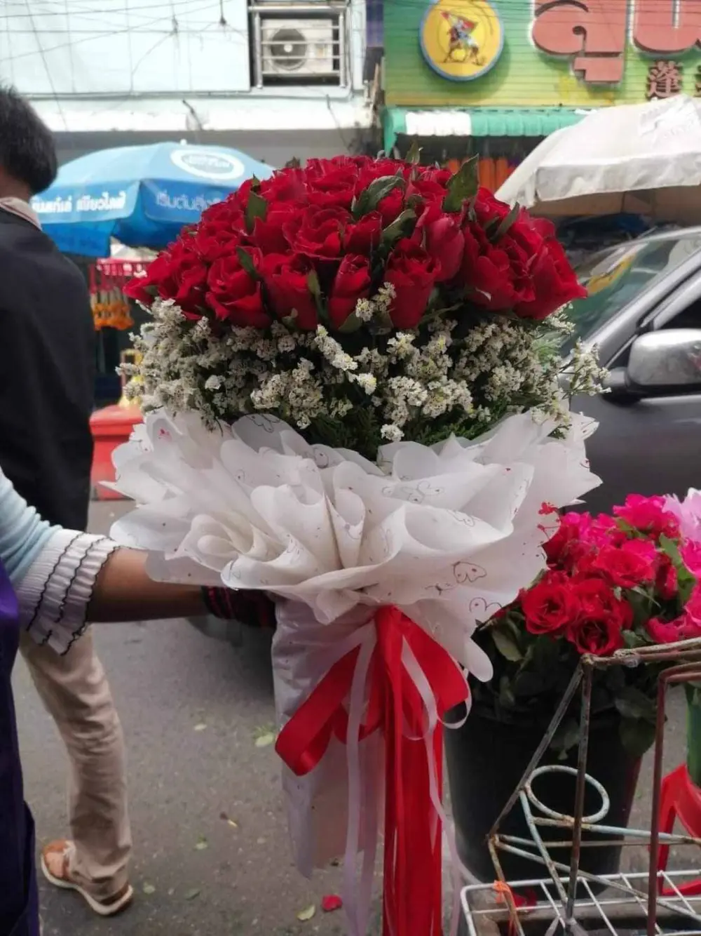 ช่อกุหลาบแดงช่อใหญ่ แซมดอกไม้ขาว ผูกโบว์